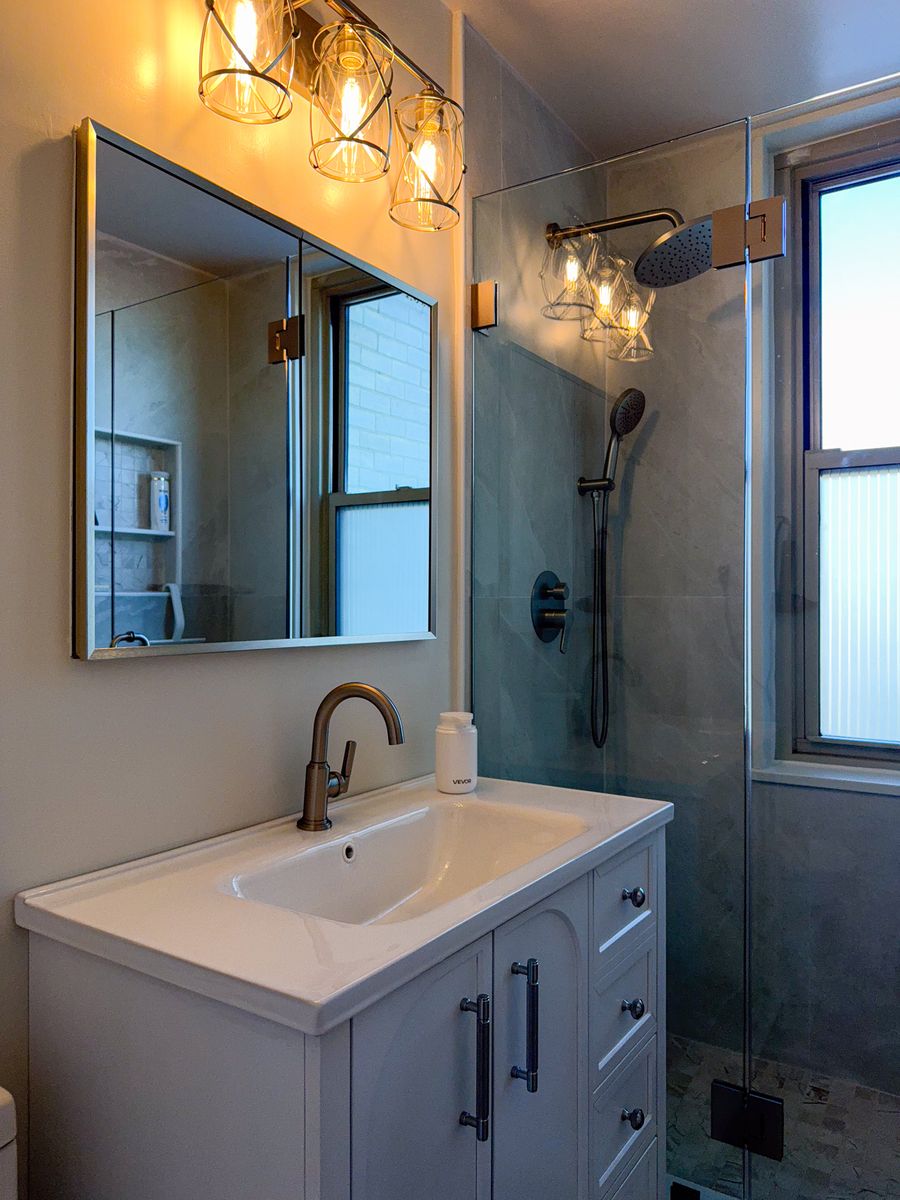 Vanity sink and medicine cabinet next to the glass shower